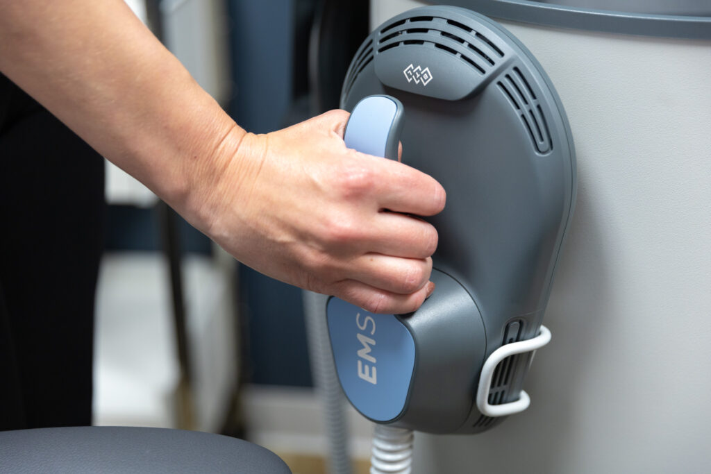 emsculpt machine close up with hand gripping the handle